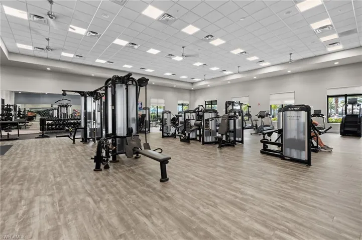 Expansive fitness center featuring wood-finish flooring, recessed lighting, and multiple exercise machines