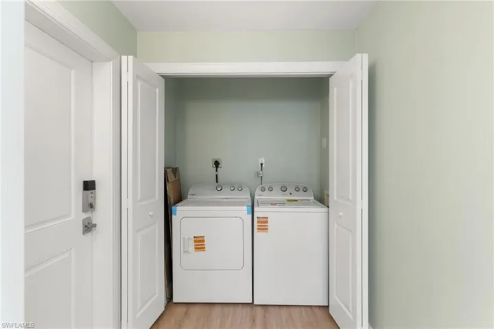 Laundry area featuring light wood-style floors and washer and dryer