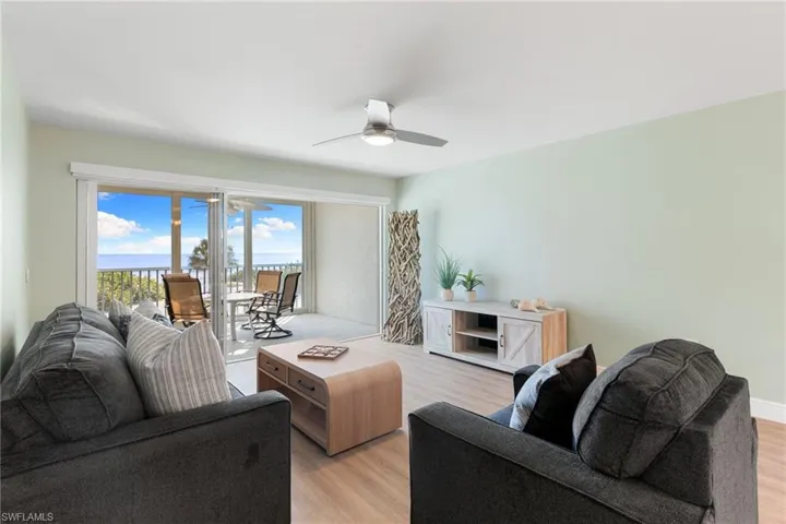 Living room with light wood-style flooring and a ceiling fan
