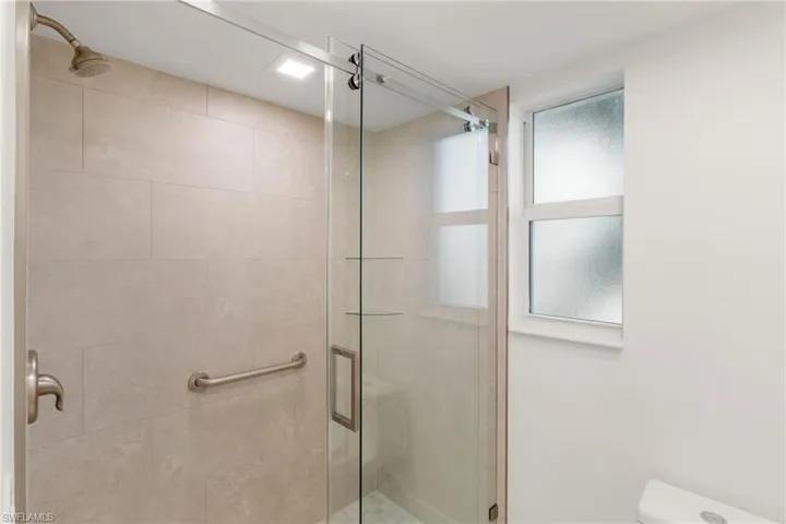 Primary bathroom featuring a shower stall and toilet