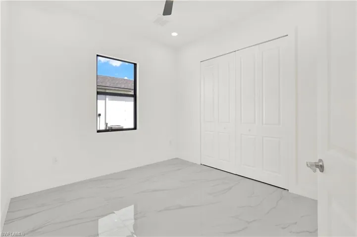 Unfurnished bedroom with light marble finish flooring, ceiling fan, recessed lighting, and a closet