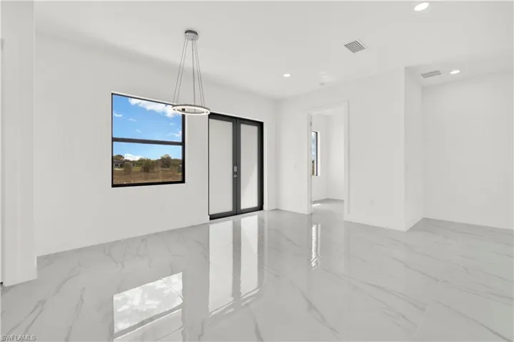 Empty room with recessed lighting and french doors