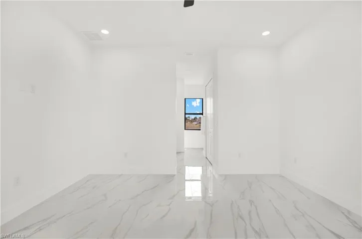 Empty room with recessed lighting and light marble finish flooring