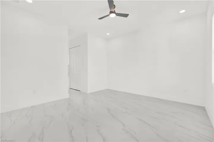 Spare room featuring recessed lighting, a ceiling fan, and light marble finish flooring