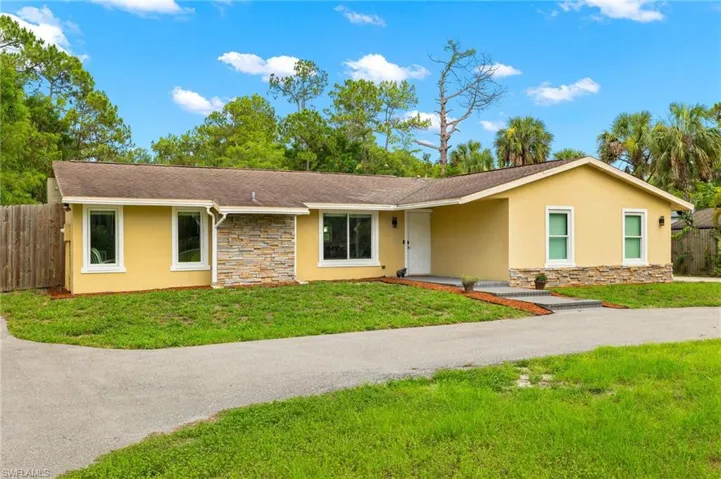 Single story home featuring stone siding, stucco siding, and a shingled roof