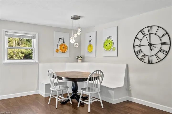 Dining area with breakfast area and dark wood-style flooring