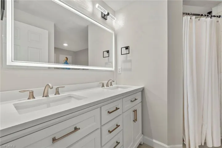 Bathroom with double vanity and a shower with curtain