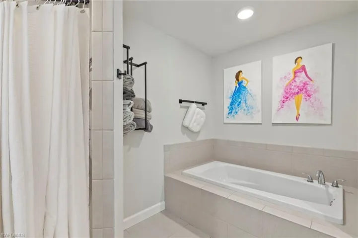 Full bath with a shower stall, a garden tub, and light tile patterned flooring