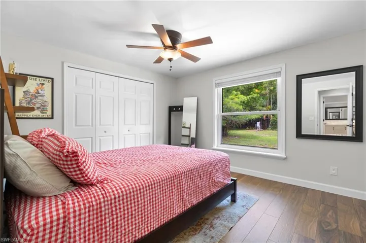 Bedroom with hardwood / wood-style floors, a ceiling fan, and a closet