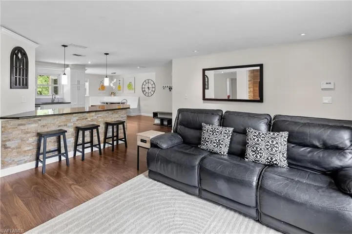 Living area with dark wood finished floors and recessed lighting