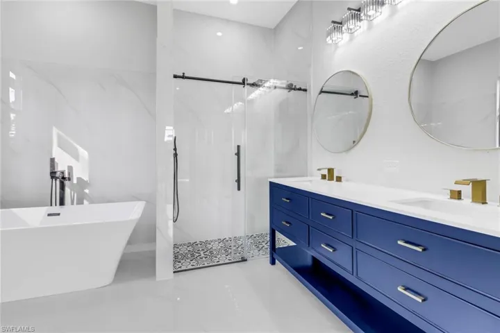 Bathroom featuring vanity and independent shower and bath