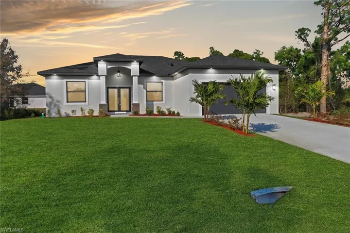 Modern home with a garage, a yard, and french doors