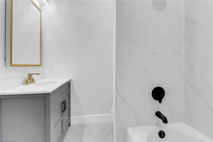 Full bathroom featuring toilet, washtub / shower combination, and vanity