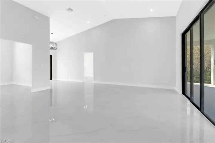 Empty room with high vaulted ceiling and a chandelier
