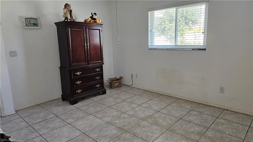 Bedroom with light tile patterned flooring and baseboards