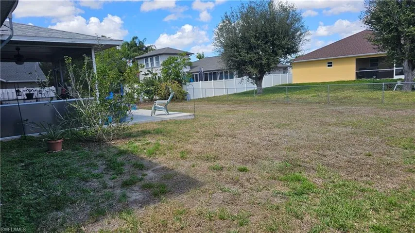 Fenced backyard with a sunroom, ceiling fan, and a patio area