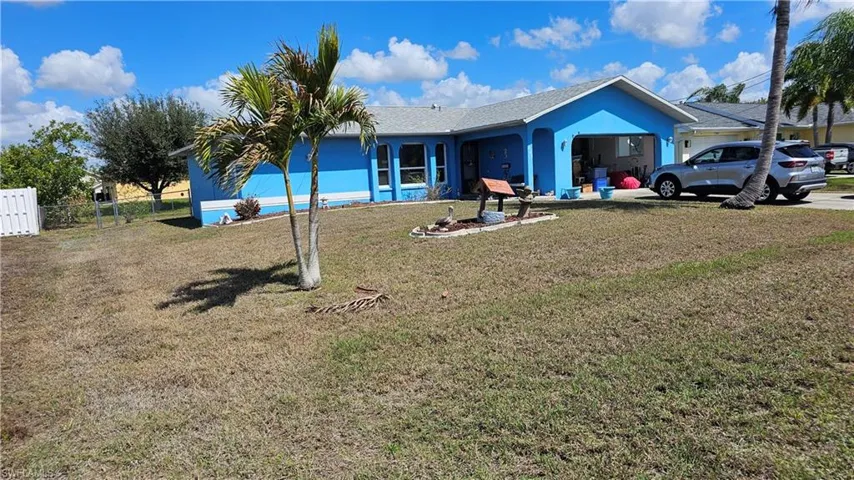 Rear view of house featuring a garage, stucco siding, and roof with shingles