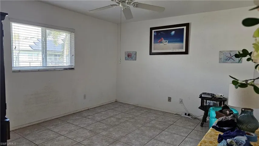 Empty room featuring a ceiling fan and light tile patterned floors