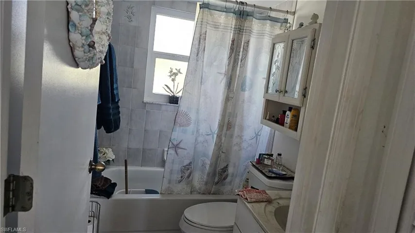 Bathroom featuring vanity and shower / bath combo with shower curtain