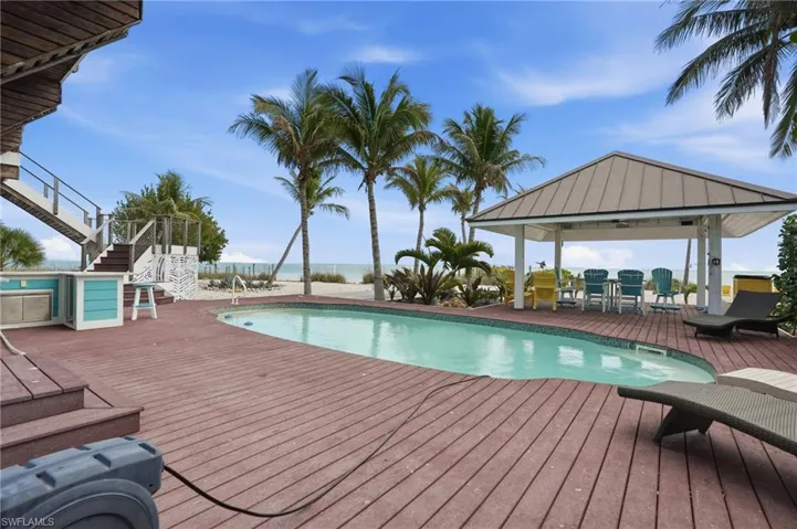 Swimming pool featuring a deck with water view and a gazebo