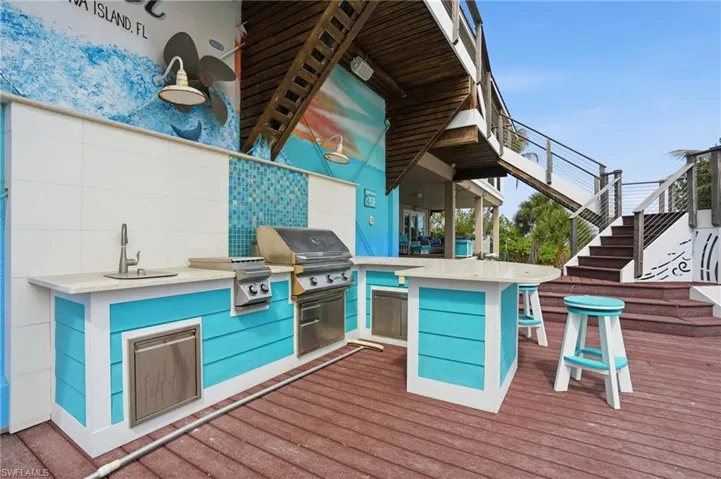 Deck featuring stairs and area for grilling