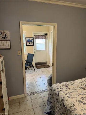 View of the guest bedroom to the sunroom and back door.  There is a second closet for each bedroom to use, giving both bedrooms two closets.