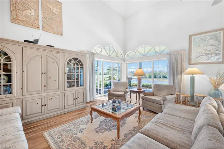 Living room with a water view, a towering ceiling, and light wood finished floors