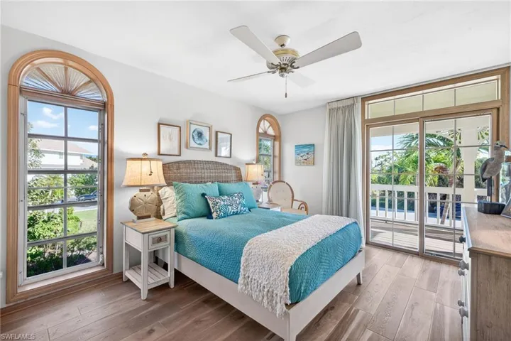 Bedroom with access to outside, wood finished floors, and ceiling fan