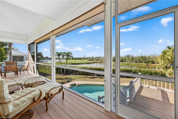 Sunroom with hardwood / wood-style floors and a water view