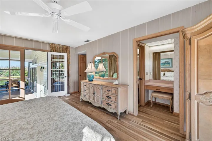 Bedroom featuring light wood finished floors, multiple windows, access to outside, and a ceiling fan