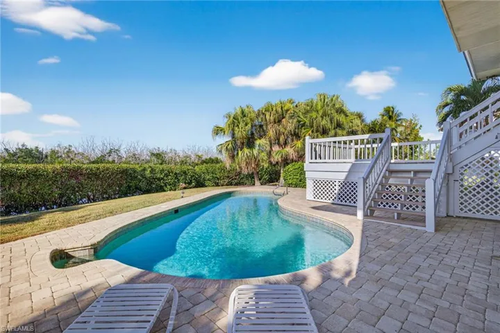 Swimming pool with a patio area, stairway, and a deck