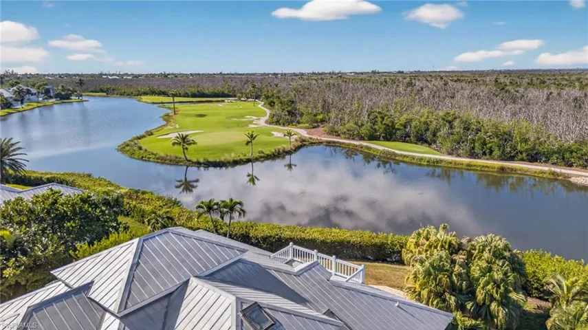 Drone / aerial view of a nearby body of water and a golf club