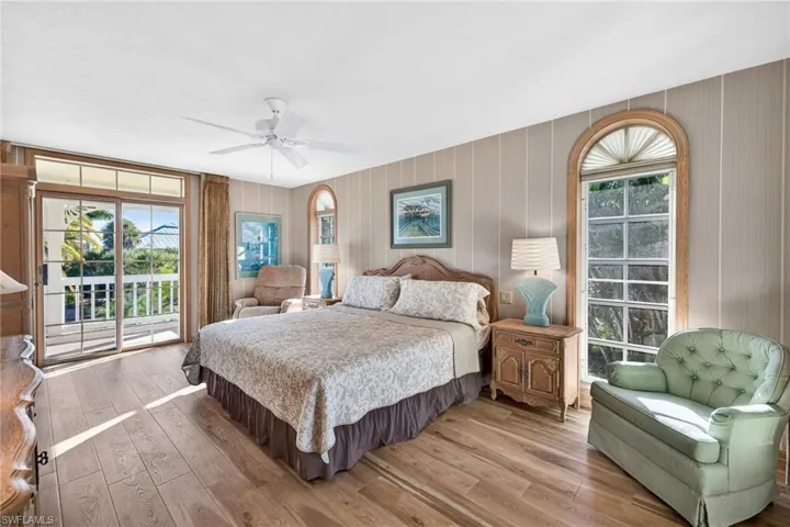 Bedroom with access to outside, light wood finished floors, and multiple windows
