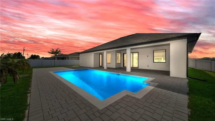 Pool at dusk with a patio area and a fenced backyard