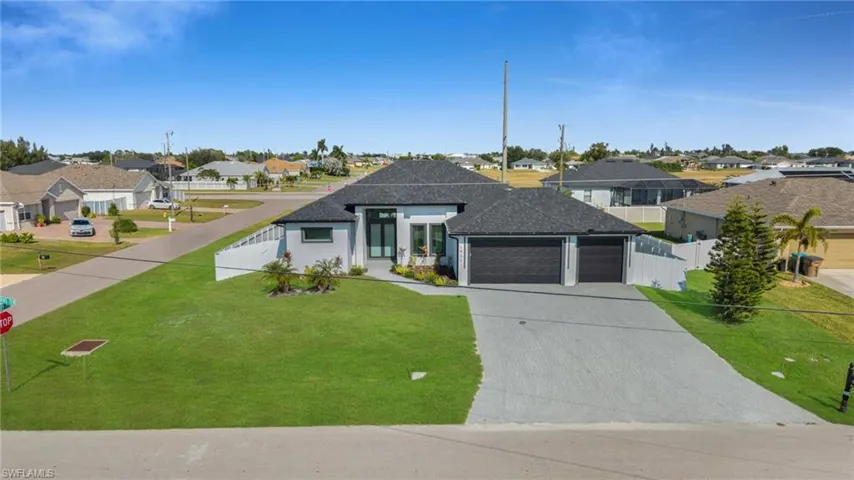 View of front facade with a residential view, driveway, a garage, and a shingled roof
