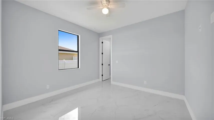 Unfurnished room featuring baseboards and light marble finish floors