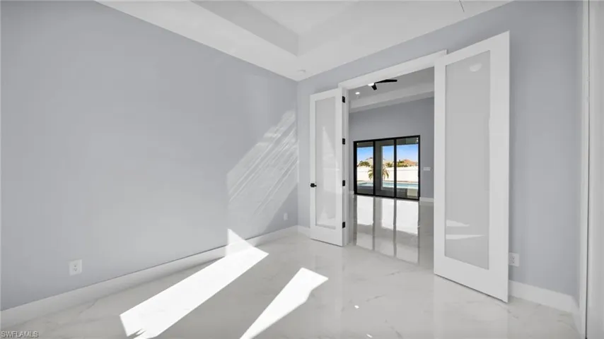 Empty room featuring french doors and light marble finish flooring