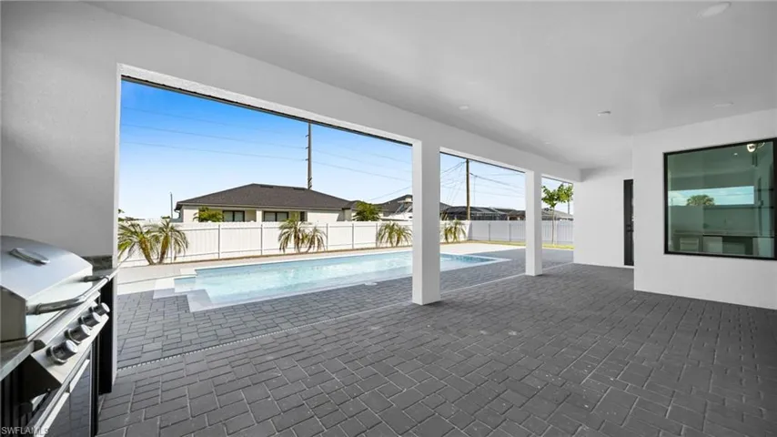 View of swimming pool with grilling area, a fenced backyard, a patio area, and a sunroom