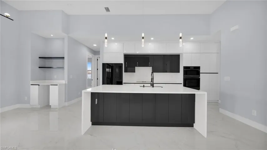 Kitchen with modern cabinets, white cabinets, decorative light fixtures, and recessed lighting