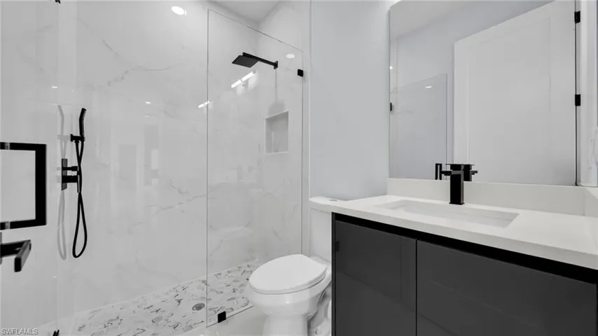 Full bath featuring vanity and a marble finish shower