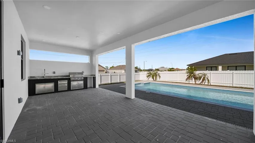 View of pool with exterior kitchen, a patio area, and a fenced backyard