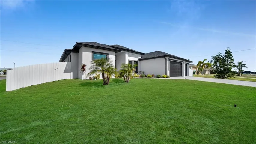 Prairie-style house featuring a front lawn, stucco siding, concrete driveway, and an attached garage