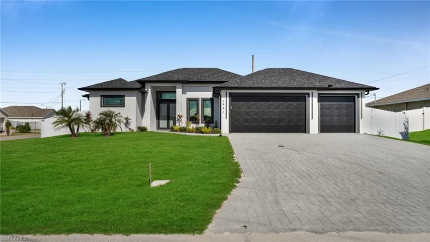 Prairie-style house with an attached garage, decorative driveway, stucco siding, and roof with shingles