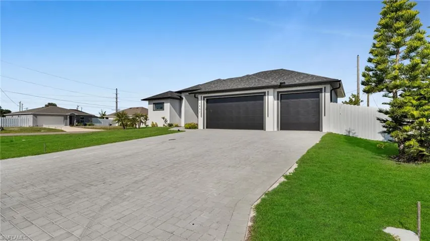 Prairie-style home featuring decorative driveway, a garage, stucco siding, and a shingled roof