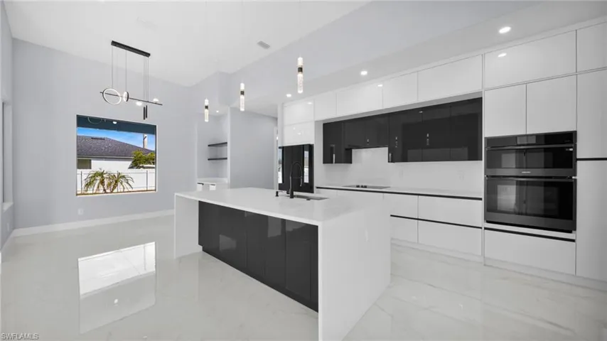 Kitchen with modern cabinets, white cabinets, and decorative light fixtures