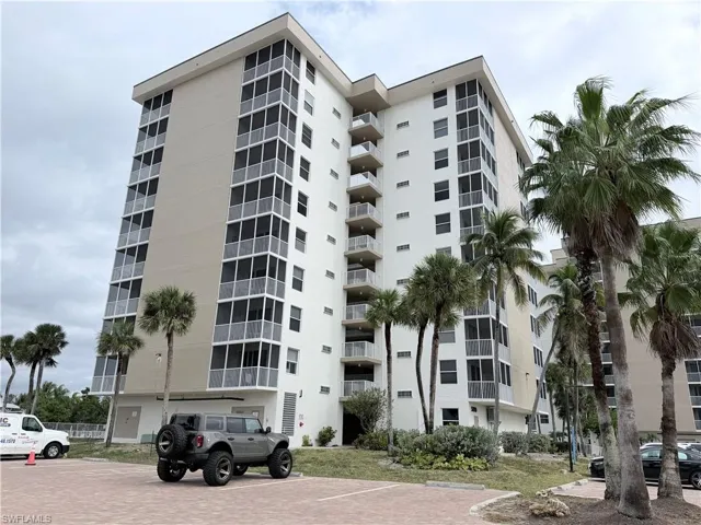 View of apartment building / complex with uncovered parking
