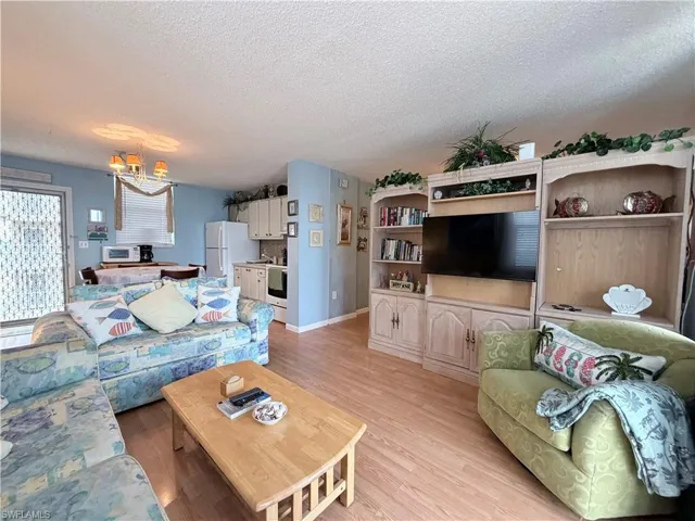 Living area featuring a textured ceiling and light wood finished floors