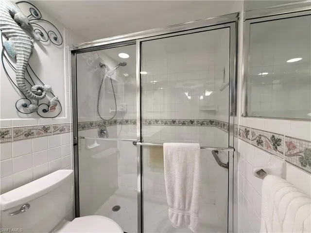 Full bath with tile walls and a shower stall
