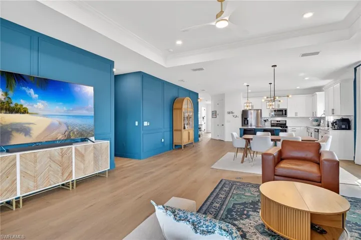 Living room featuring a ceiling fan, recessed lighting, and decorative molding