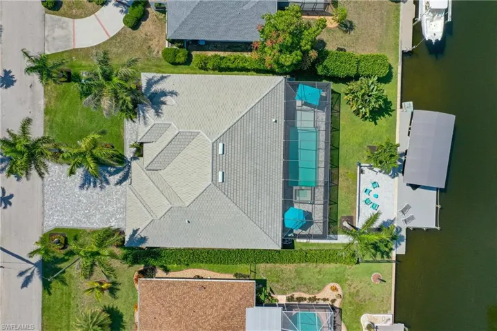 Aerial view of property and surrounding area with a nearby body of water